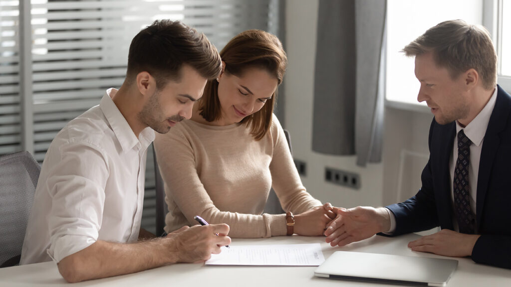 Mobile notary signing important legal documents at a table, one person guiding another through the process. Travel notary apostille